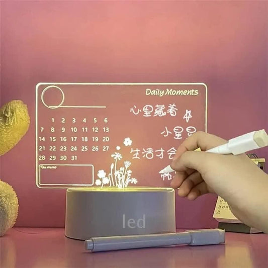 LED writing board with calendar and floral design, hand holding marker on pink background