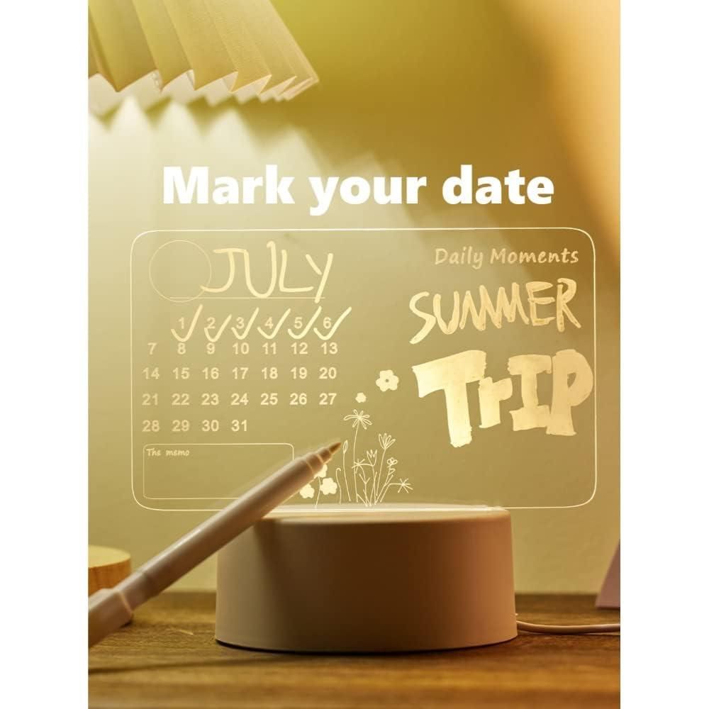 Glowing calendar and 'Summer Trip' text on a wooden surface with a pen.
